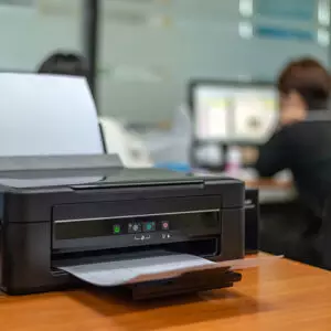 black printer in office with soft-focus and over light in the background