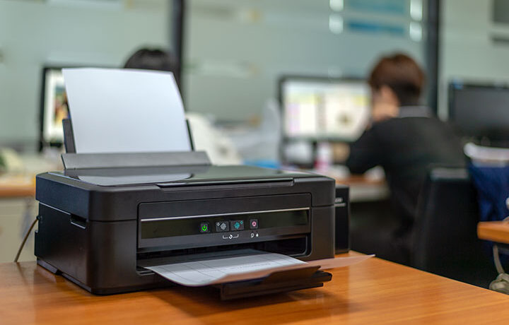 black printer in office with soft-focus and over light in the background